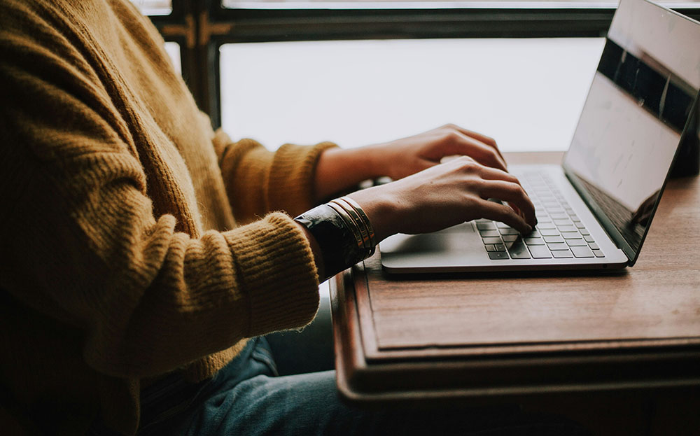 Person's hands, typing on a computer